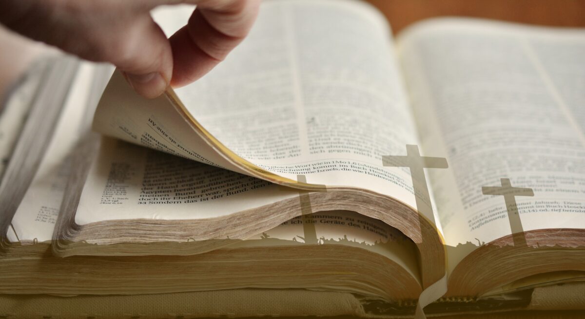 Lifting pages of a Bible with three crosses overlay